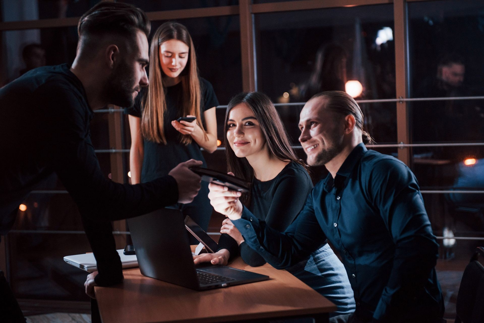 Take this notepad. Team of young business people works on their project at night time in the office. Take this notepad. Team of young business people works on their project at night time in the office.